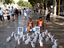 02.08.07. AnimaNaturalis protestó contra la experimentación con animales con dos activistas que se embadurnaron de crema solar ensangrentada con un cartel que decía: ¿Cuántos animales mata tu crema solar?